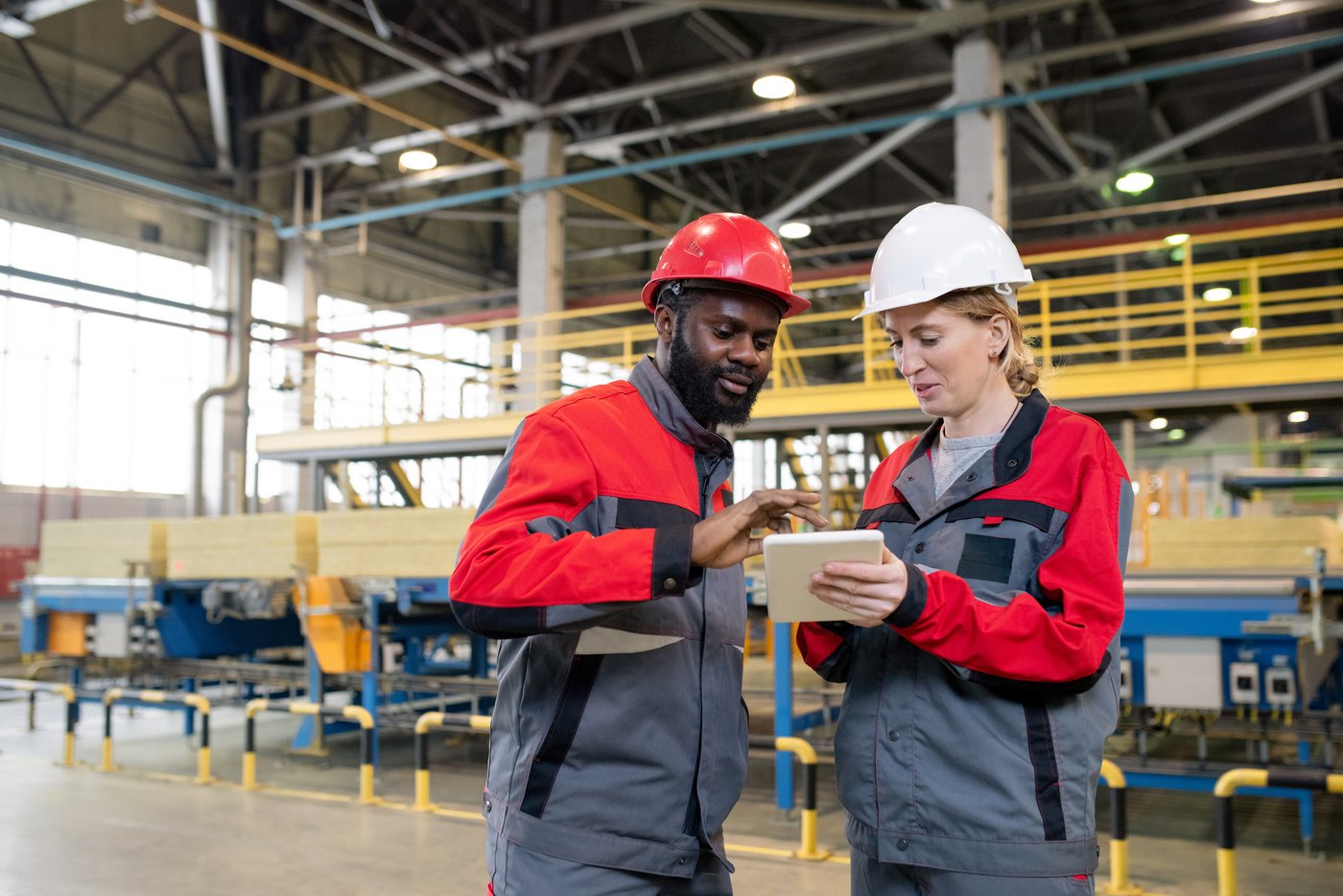 Two technicians reviewing a tablet on a production floor