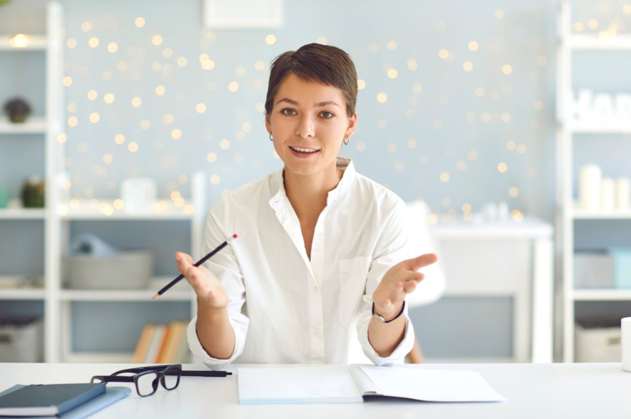 A specification writer at a desk explaining a point with a pencil in hand