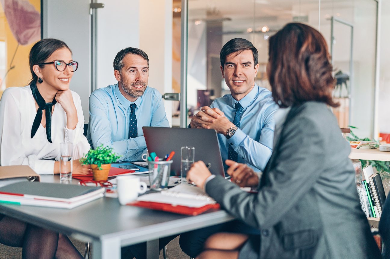 Three people listening across a conference table
